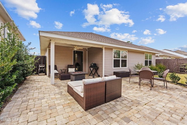 view of patio / terrace featuring a ceiling fan, an outdoor living space with a fire pit, and fence