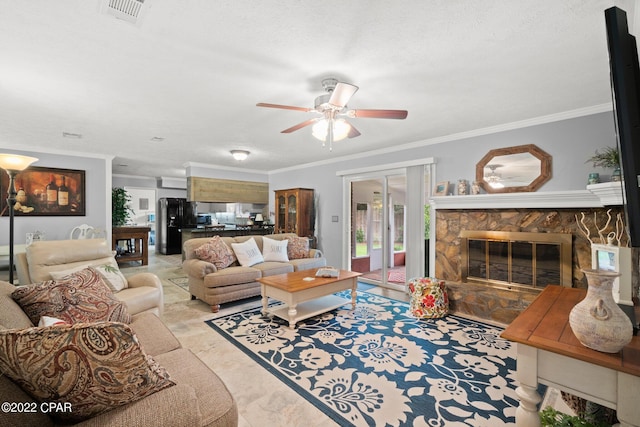 living area featuring crown molding, visible vents, a fireplace, and ceiling fan