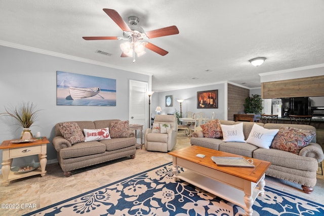 living room featuring ceiling fan, visible vents, and ornamental molding