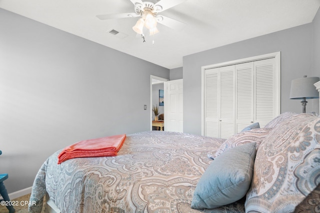 bedroom with a ceiling fan, a closet, visible vents, and baseboards