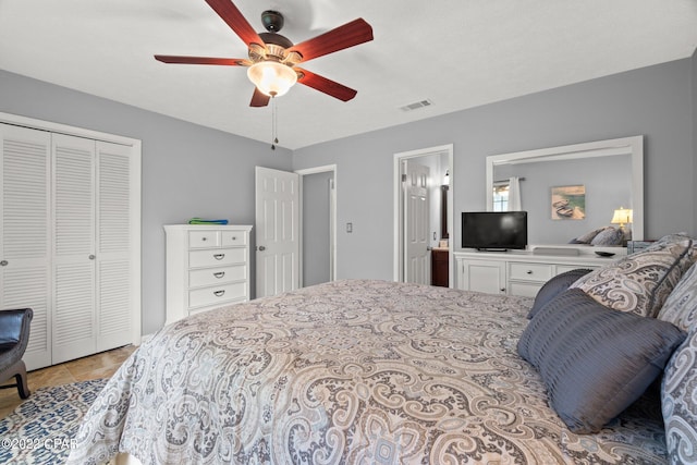 bedroom featuring a closet, light tile patterned flooring, visible vents, and a ceiling fan