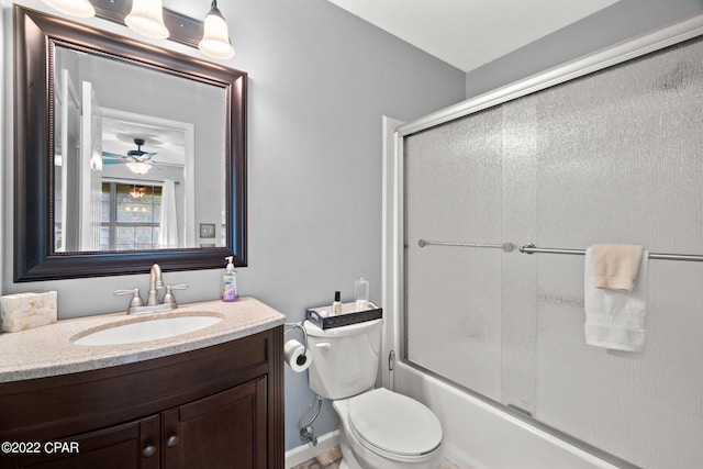 bathroom with toilet, shower / bath combination with glass door, and vanity