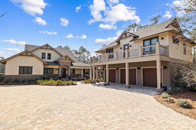 view of front of home with a garage, decorative driveway, board and batten siding, and a balcony