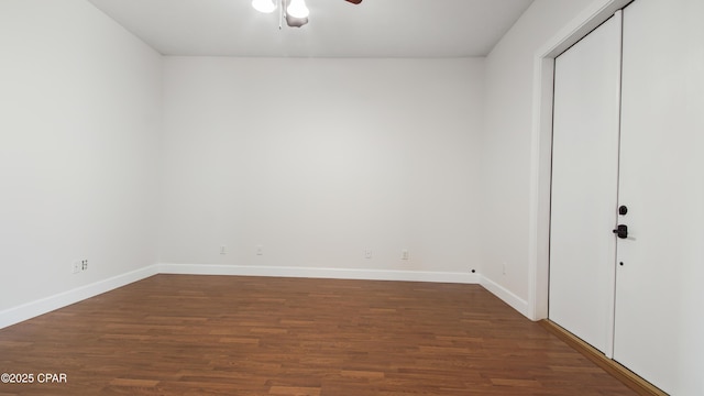 empty room with ceiling fan, dark wood-type flooring, and baseboards