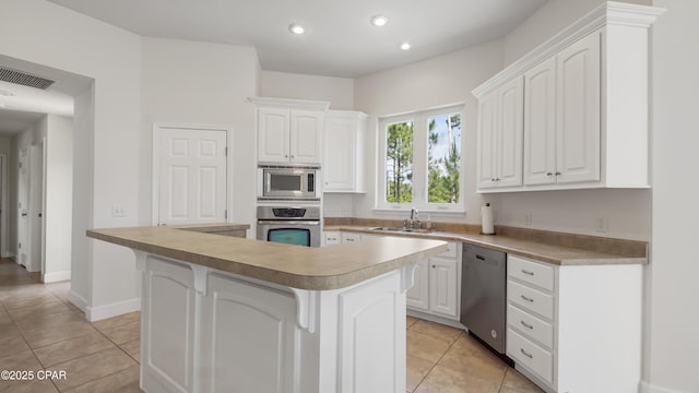 kitchen with visible vents, appliances with stainless steel finishes, white cabinets, and a sink