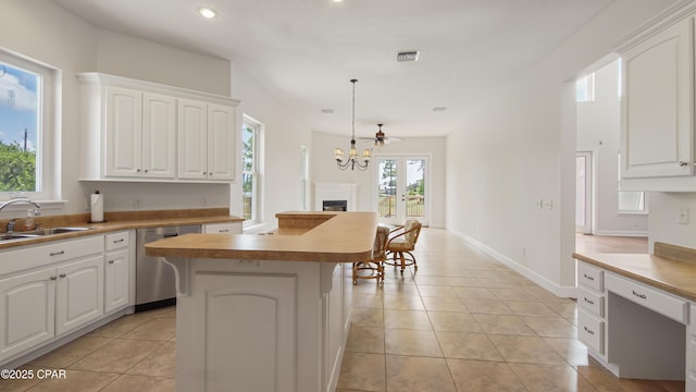 kitchen with a center island, visible vents, stainless steel dishwasher, white cabinets, and a sink