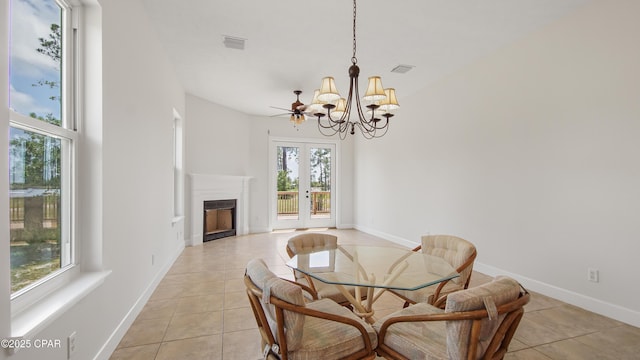 dining area with light tile patterned floors, baseboards, visible vents, a fireplace, and a notable chandelier