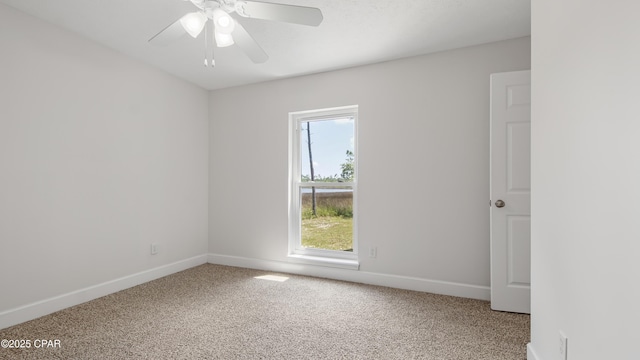 unfurnished room with a ceiling fan, carpet flooring, and baseboards