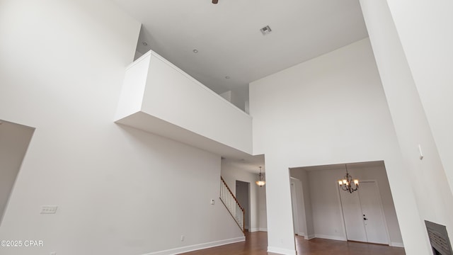 interior space featuring a chandelier, visible vents, baseboards, and wood finished floors