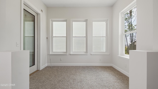 unfurnished room with baseboards and carpet flooring