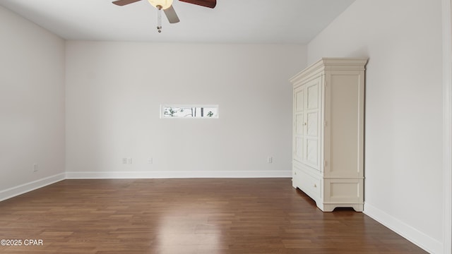 unfurnished room with dark wood-type flooring, baseboards, and a ceiling fan