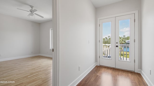 doorway featuring a ceiling fan, french doors, baseboards, and wood finished floors