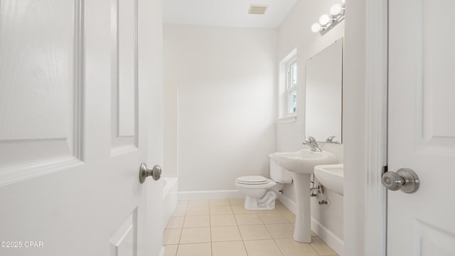 full bathroom featuring a tub to relax in, visible vents, baseboards, toilet, and tile patterned flooring