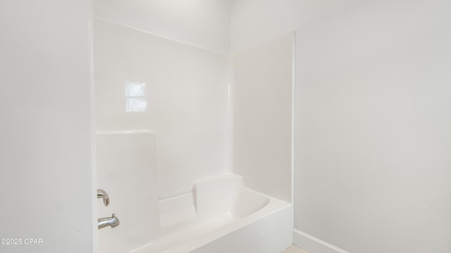 full bathroom featuring bathing tub / shower combination and baseboards