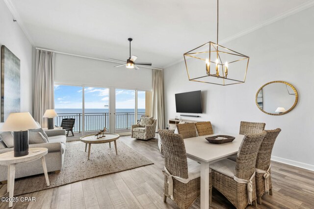 6627 Thomas Dr Unit 1702, Panama City Beach, FL 32408 - dining space with ceiling fan with notable chandelier, wood finished floors, baseboards, and ornamental molding