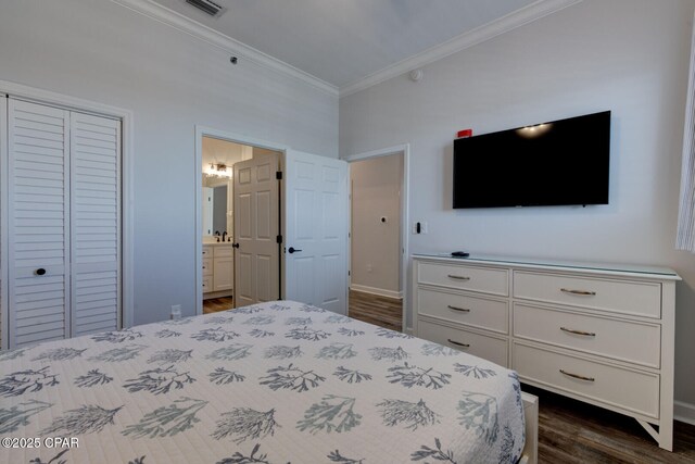 6627 Thomas Dr Unit 1702, Panama City Beach, FL 32408 - unfurnished bedroom with baseboards, dark wood-type flooring, a closet, crown molding, and connected bathroom