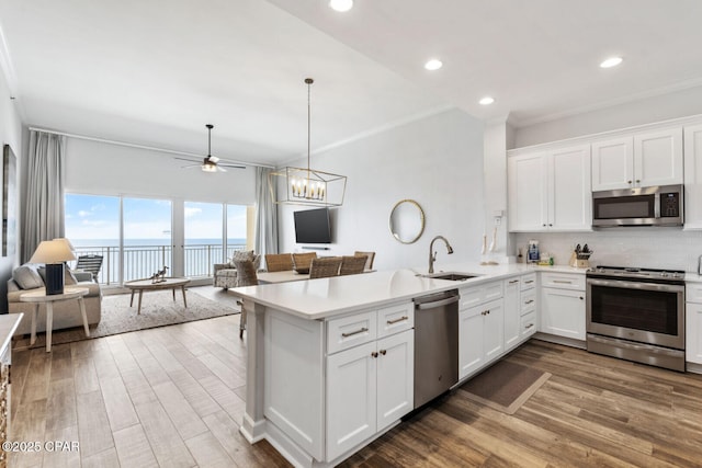 6627 Thomas Dr Unit 1702, Panama City Beach, FL 32408 - kitchen with a sink, open floor plan, stainless steel appliances, a peninsula, and light countertops
