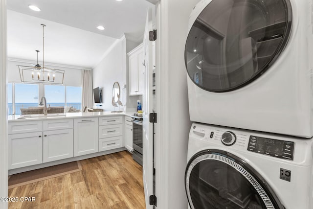 6627 Thomas Dr Unit 1702, Panama City Beach, FL 32408 - laundry room featuring light wood-type flooring, a sink, recessed lighting, stacked washer / drying machine, and a chandelier
