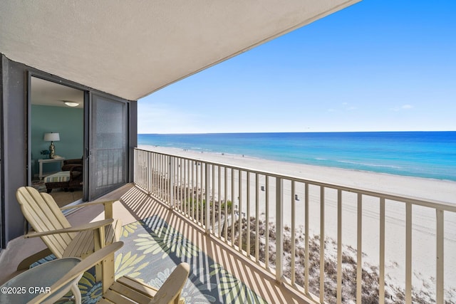 balcony featuring a beach view and a water view