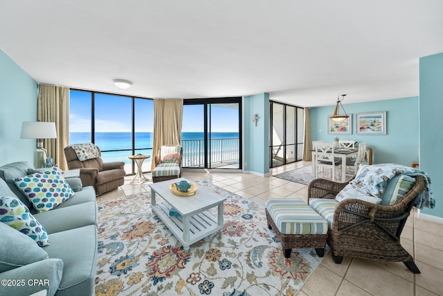 living area with tile patterned flooring, a wall of windows, baseboards, and a water view