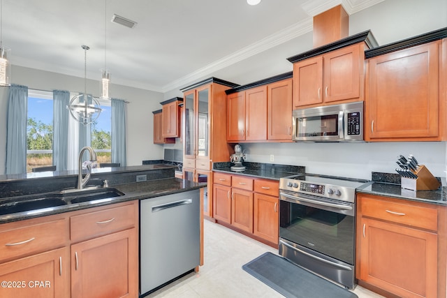 kitchen with dark stone counters, visible vents, stainless steel appliances, and ornamental molding