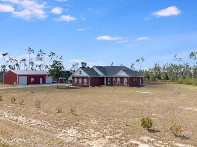 ranch-style house featuring a detached garage and an outbuilding