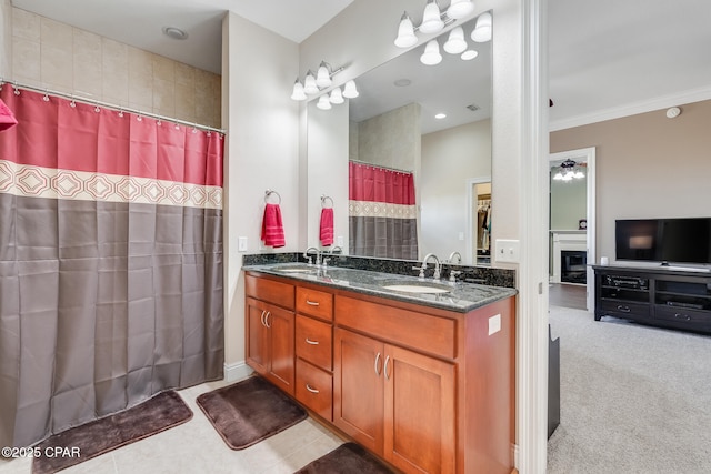 bathroom featuring ornamental molding, a sink, a shower with shower curtain, and double vanity