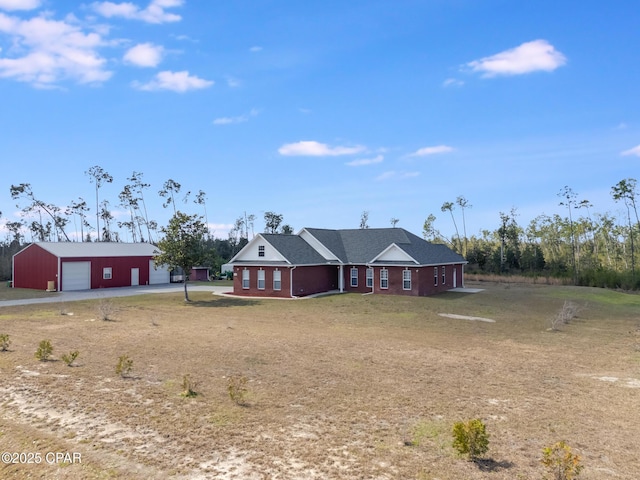 view of front facade featuring driveway, a detached garage, and an outdoor structure