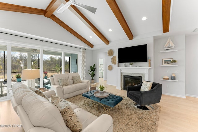 living area featuring beam ceiling, recessed lighting, light wood-style flooring, a high end fireplace, and baseboards