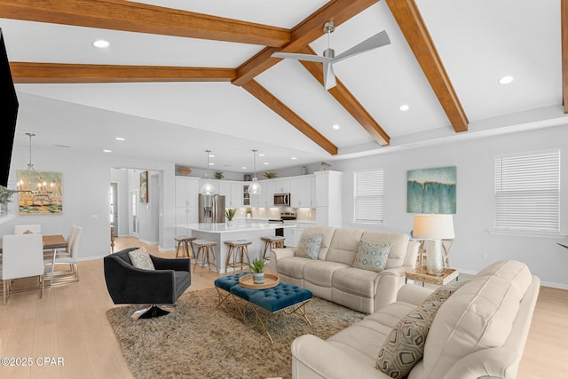 living room featuring a chandelier, beamed ceiling, light wood-style flooring, and baseboards