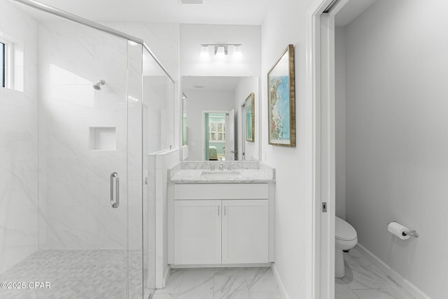 bathroom with marble finish floor, a shower stall, toilet, and baseboards