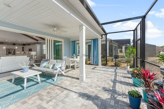 sunroom featuring a ceiling fan and beamed ceiling