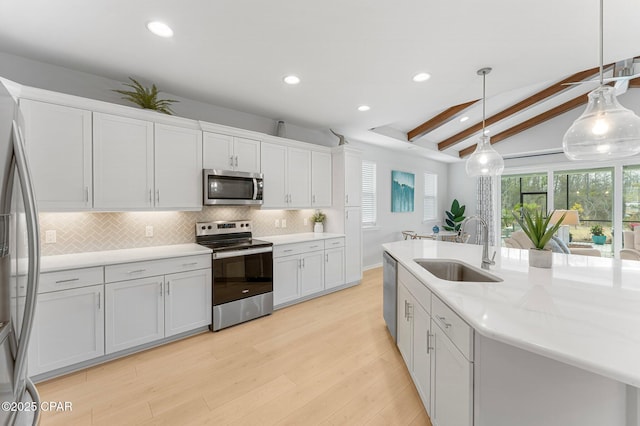 kitchen featuring decorative backsplash, lofted ceiling with beams, stainless steel appliances, white cabinetry, and a sink