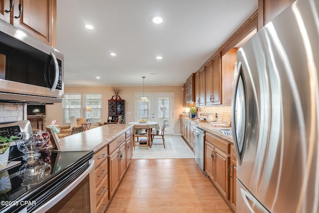 kitchen featuring tasteful backsplash, appliances with stainless steel finishes, light countertops, light wood-type flooring, and recessed lighting