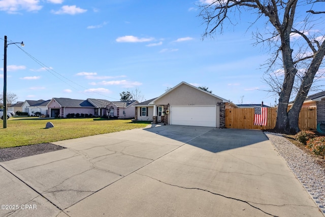 ranch-style house with an attached garage, concrete driveway, a gate, stucco siding, and a front yard