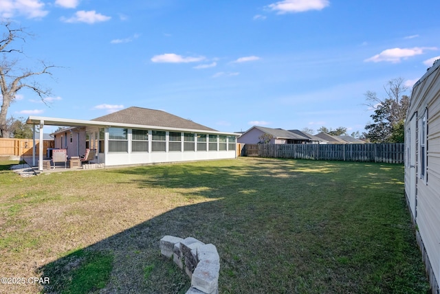 view of yard featuring a sunroom and a fenced backyard