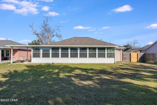 back of property with a yard, a gate, fence, and a sunroom