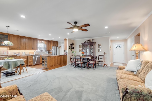 living room featuring crown molding, baseboards, visible vents, and light colored carpet