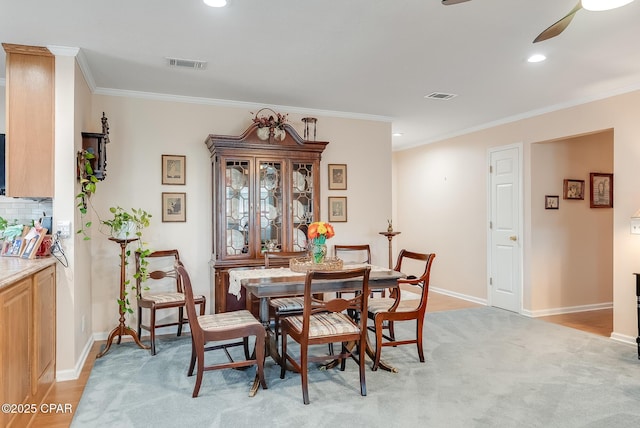 dining space featuring baseboards, visible vents, and crown molding