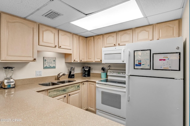 kitchen featuring light countertops, visible vents, light brown cabinets, a sink, and white appliances