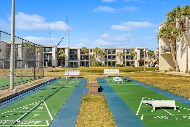 view of property's community with fence and a lawn