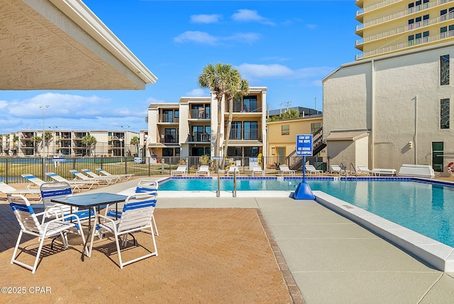 community pool with fence and a patio