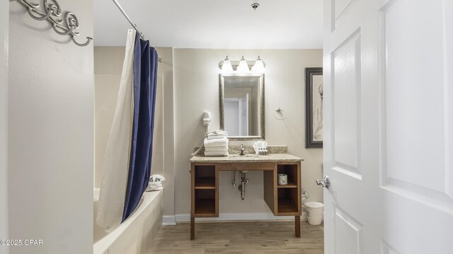 full bath with wood finished floors, vanity, and shower / tub combo with curtain