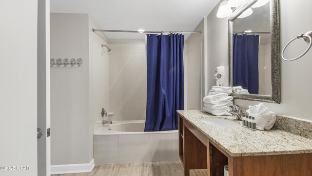 bathroom featuring wood finished floors, shower / bath combination with curtain, and vanity