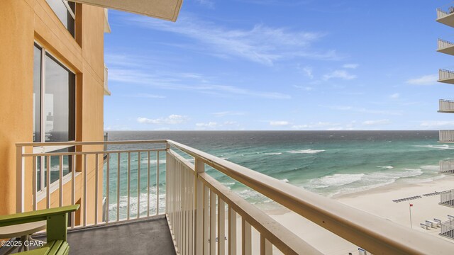 balcony featuring a water view and a beach view