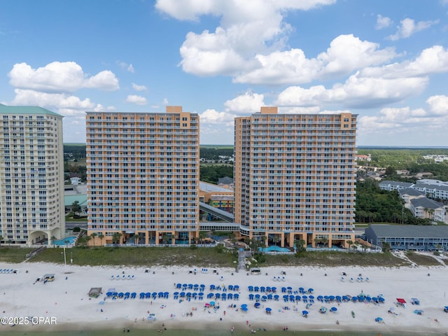 drone / aerial view featuring a view of the beach, a city view, and a water view