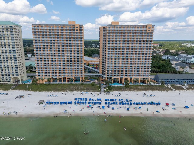drone / aerial view featuring a view of the beach, a water view, and a city view