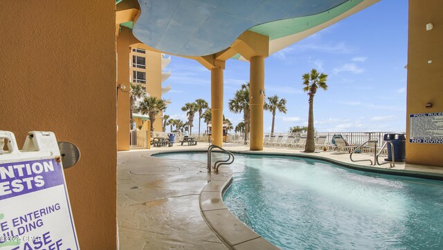 community pool featuring fence and a patio