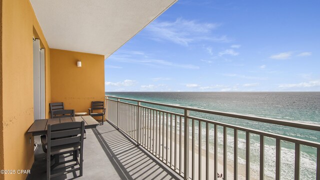 balcony featuring a view of the beach and a water view