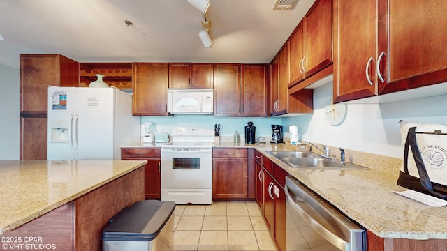 kitchen featuring visible vents, light tile patterned flooring, a sink, light stone countertops, and white appliances